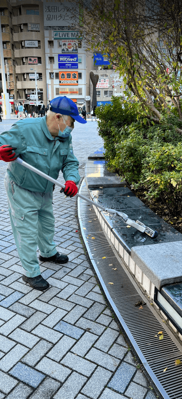Un aîné nettoie un parc de Tokyo